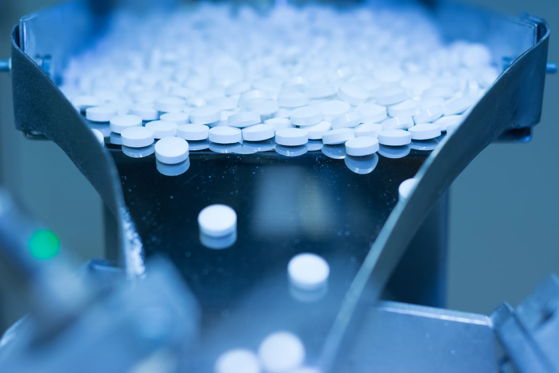 Health supplement tablets moving through a manufacturing line