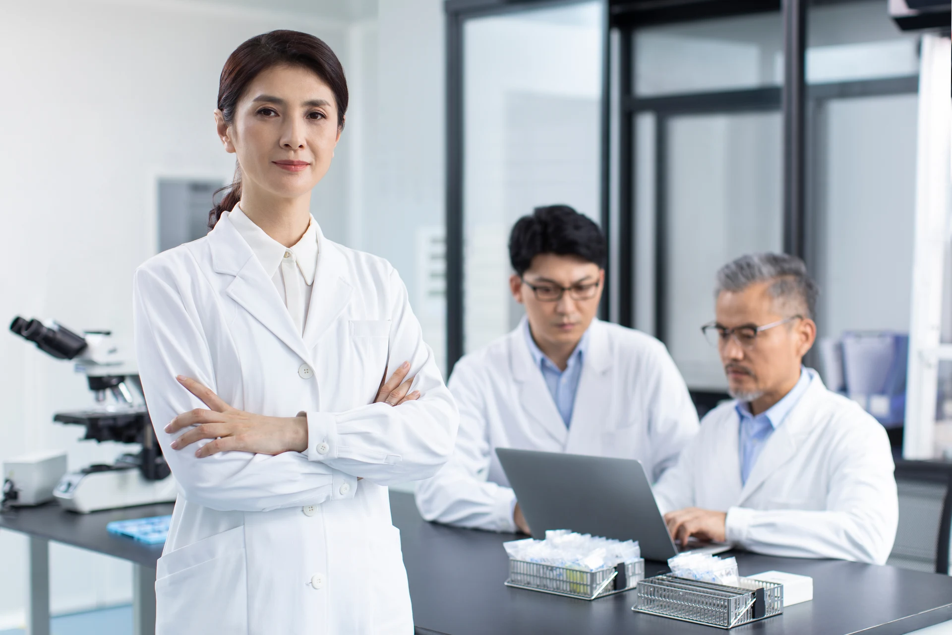 A laboratory leader with researchers reviewing their work